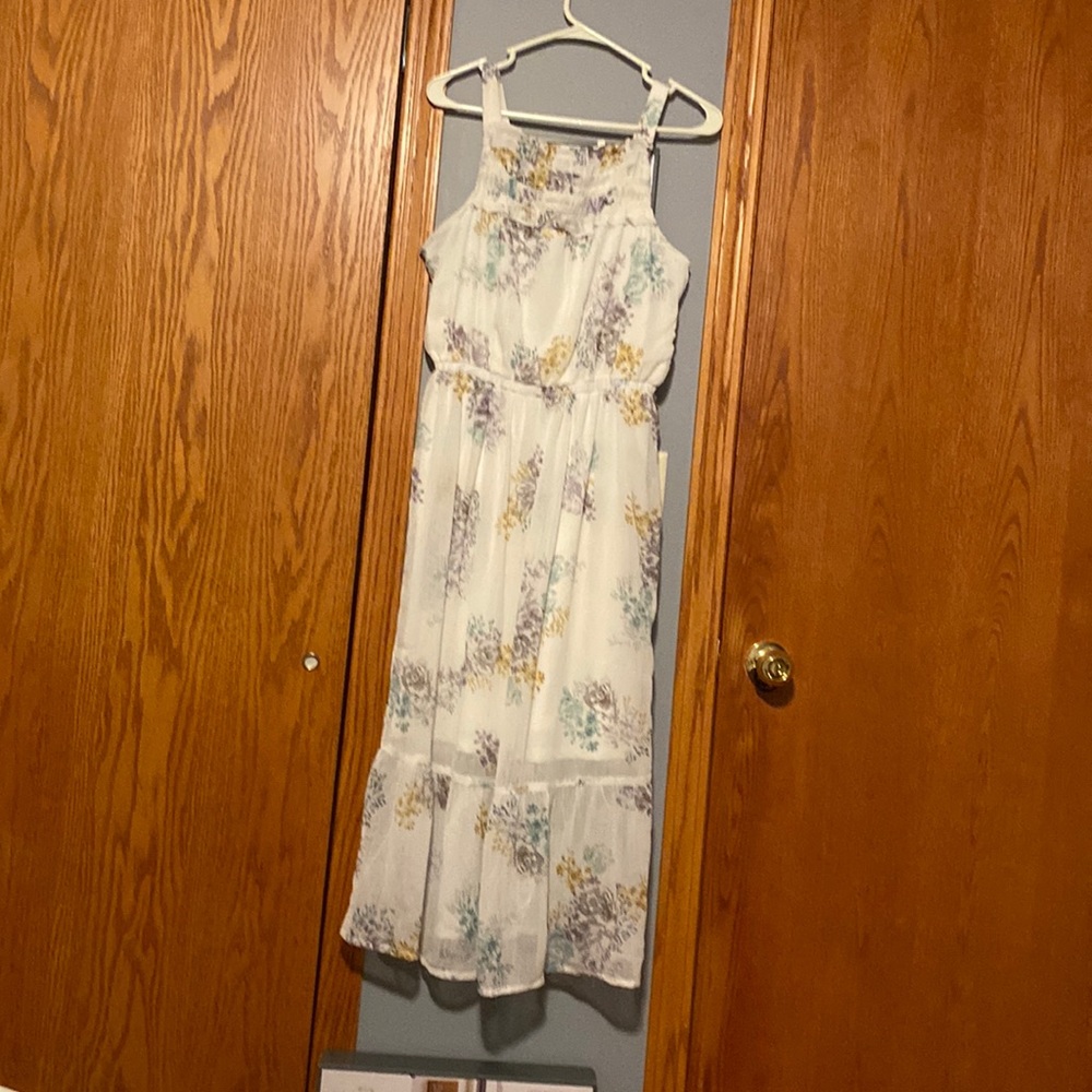 Can fit a medium, it’s a size small. White with floral design